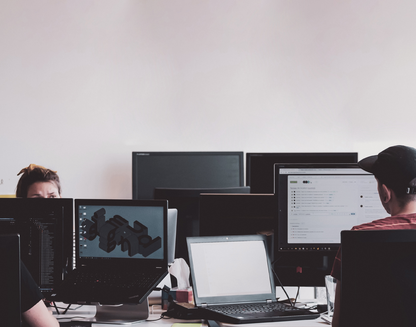 Person working at multiple computer screens