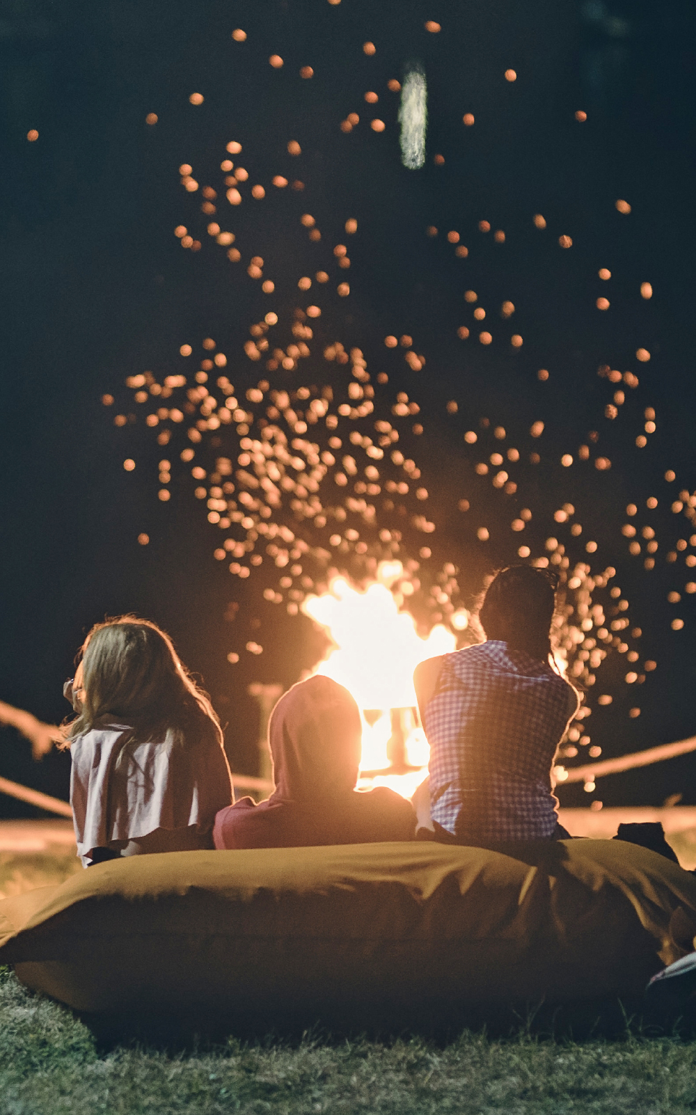 Camping: friends sitting around a campfire