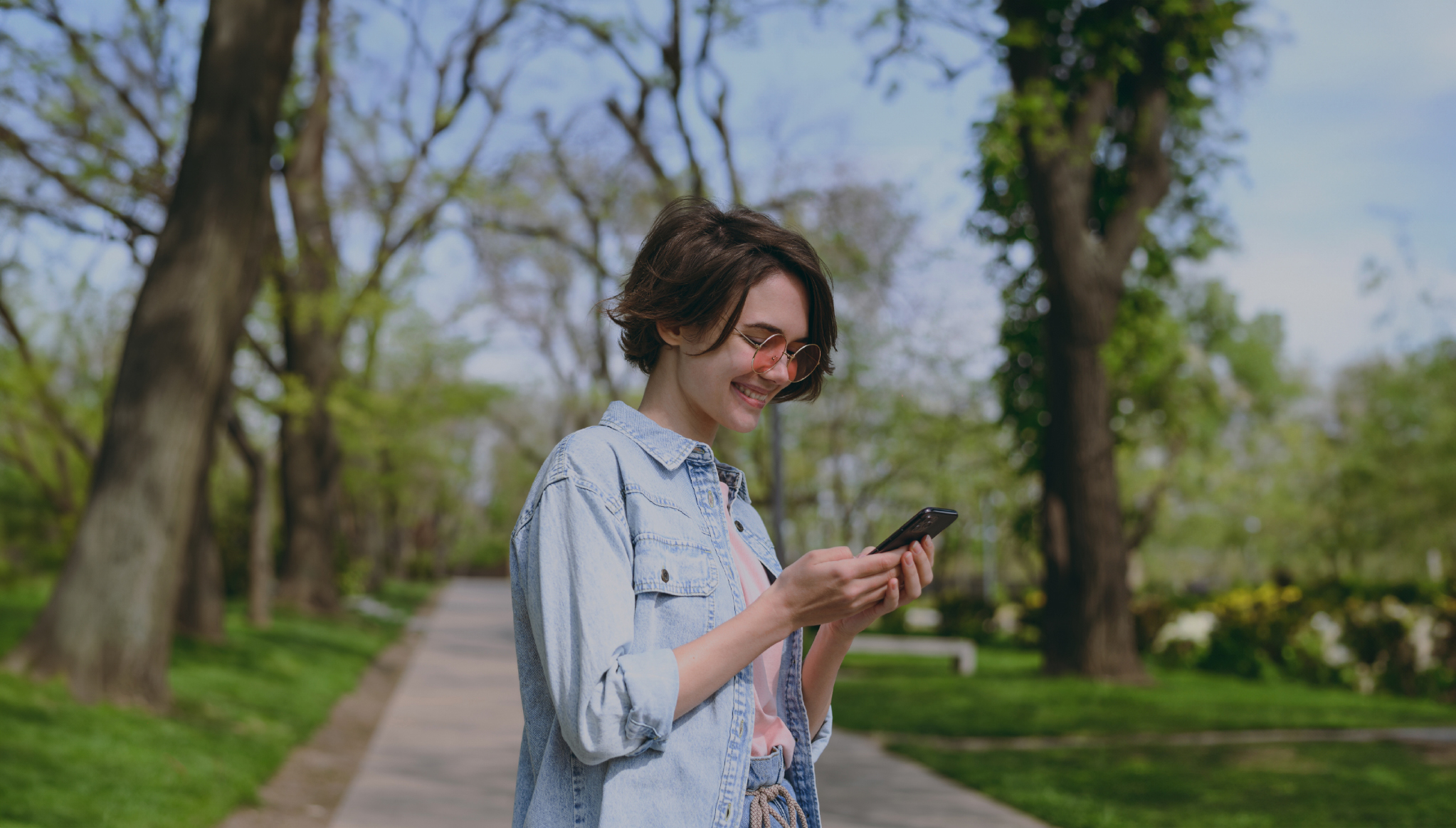 Woman using her phone outdoors in a park