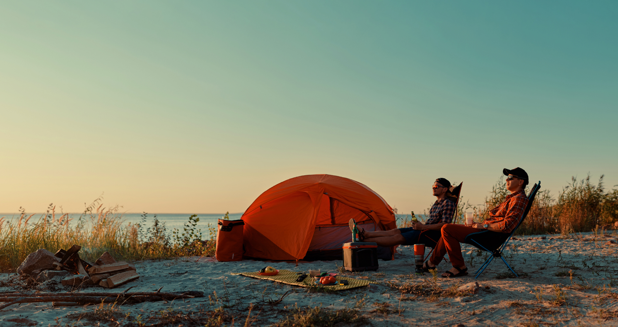 Stay Connected: friends beside a tent by the water at sunset