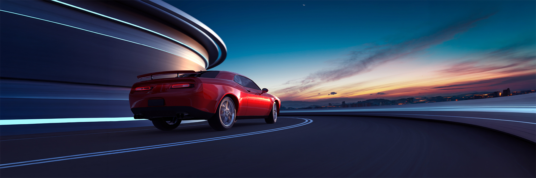 Red sports car on a road at sunset